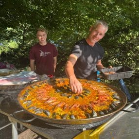 Taco bereidt Paella Mixta tijdens een verjaardagsfeest op een eiland